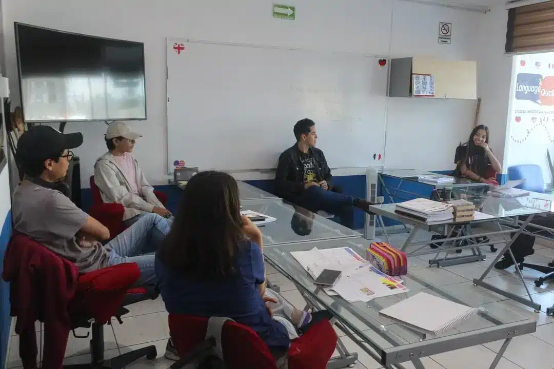 Alumnos participando en una clase presencial dentro de un centro de idiomas en Puebla, con un ambiente educativo moderno y colaborativo.